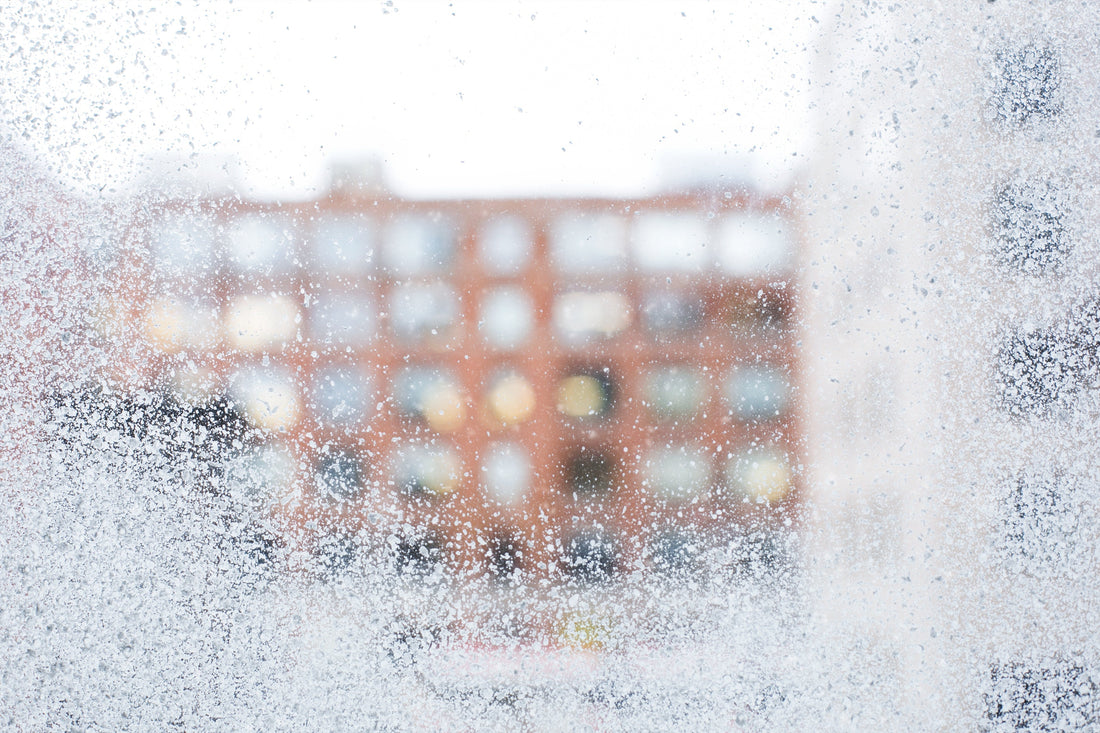 frosted window looking out to an apartment block