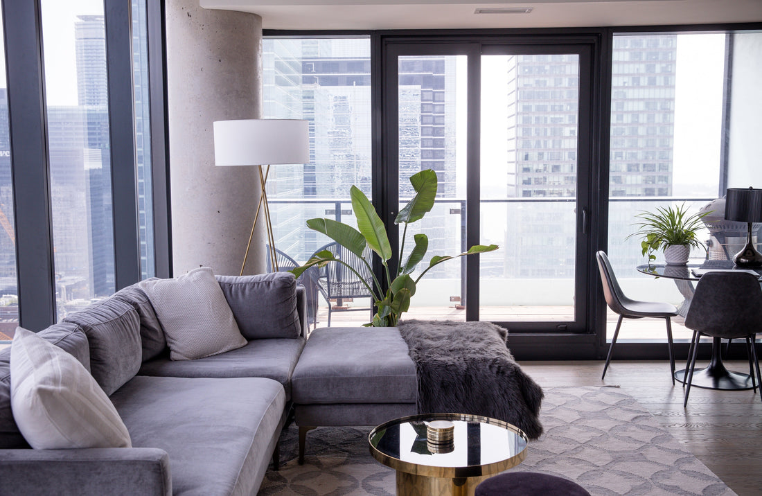living room with sofa, coffee table, lamp, dining table, chairs and view of the city
