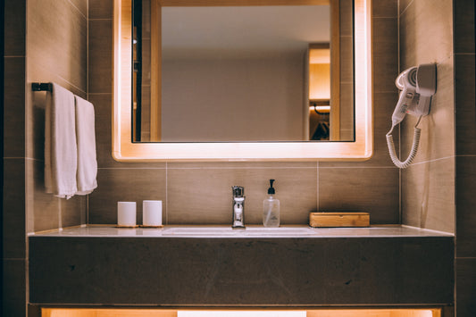 Bathroom mirror above sink. Hand towels, soap and hairdryer 