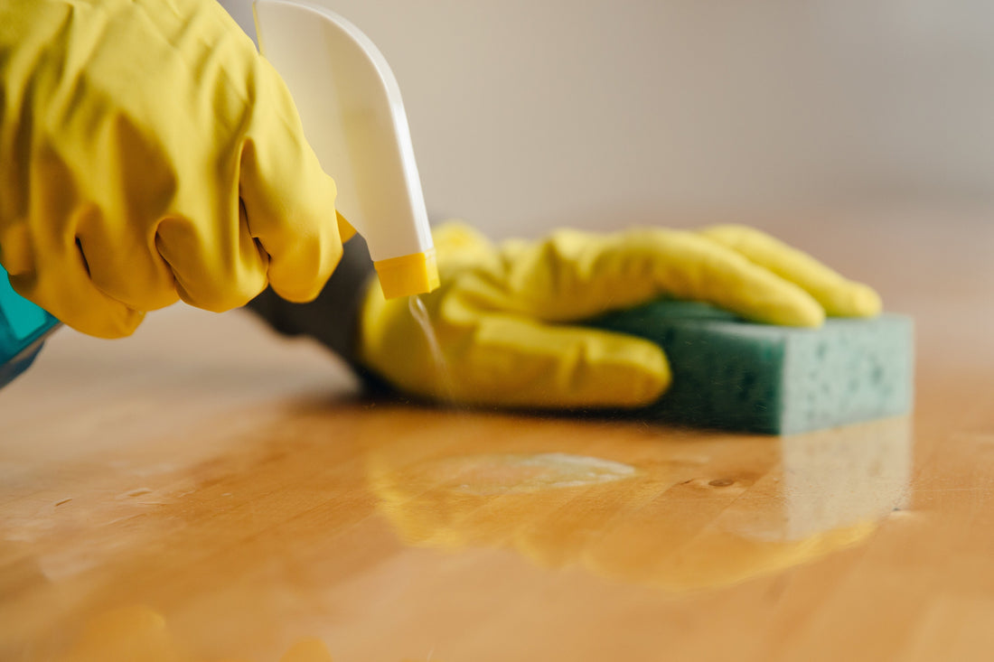 spraying cleaning spray on wooden surface 