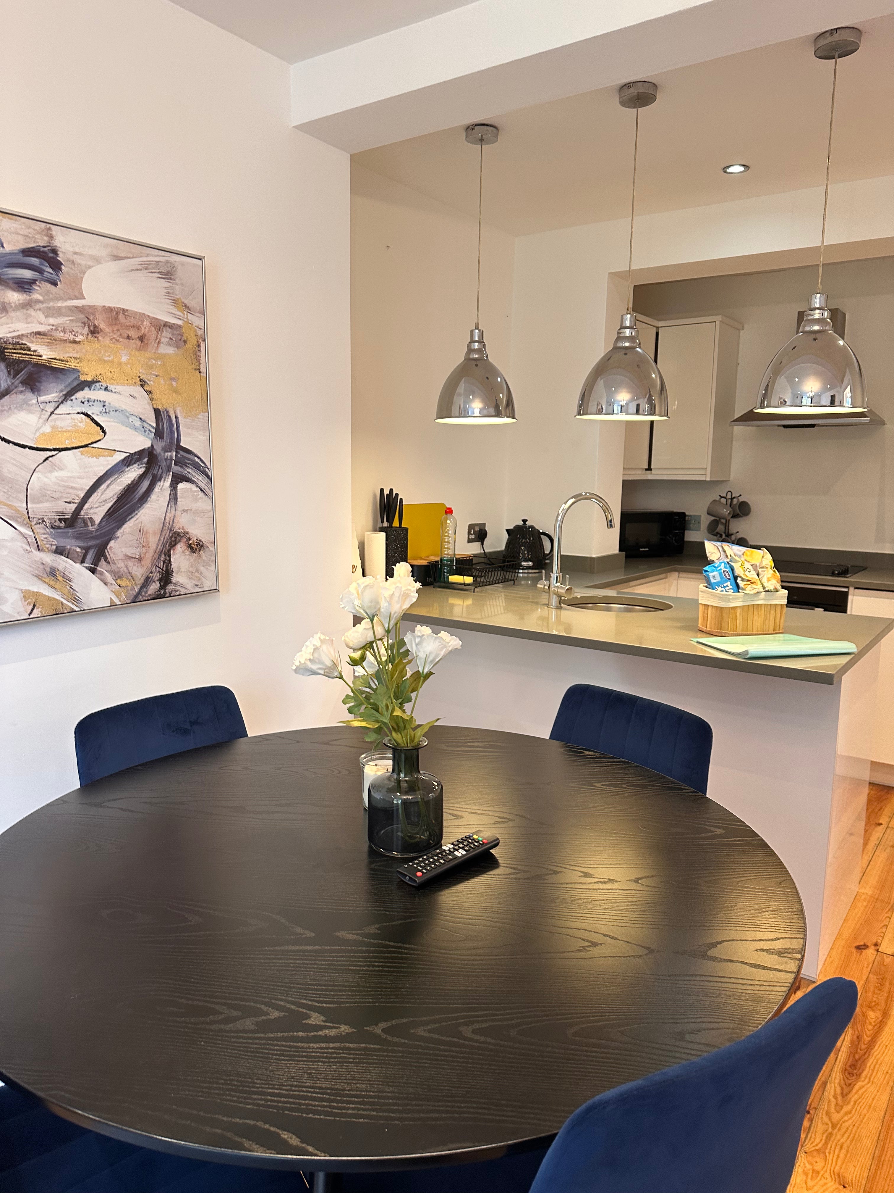 Modern kitchen with round dining table and blue chairs
